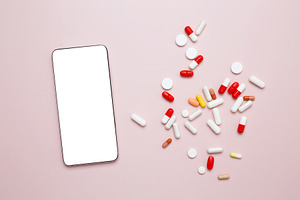 Colorful capsules and a smartphone on a surface, representing medicine and heal, a Photo by matucha