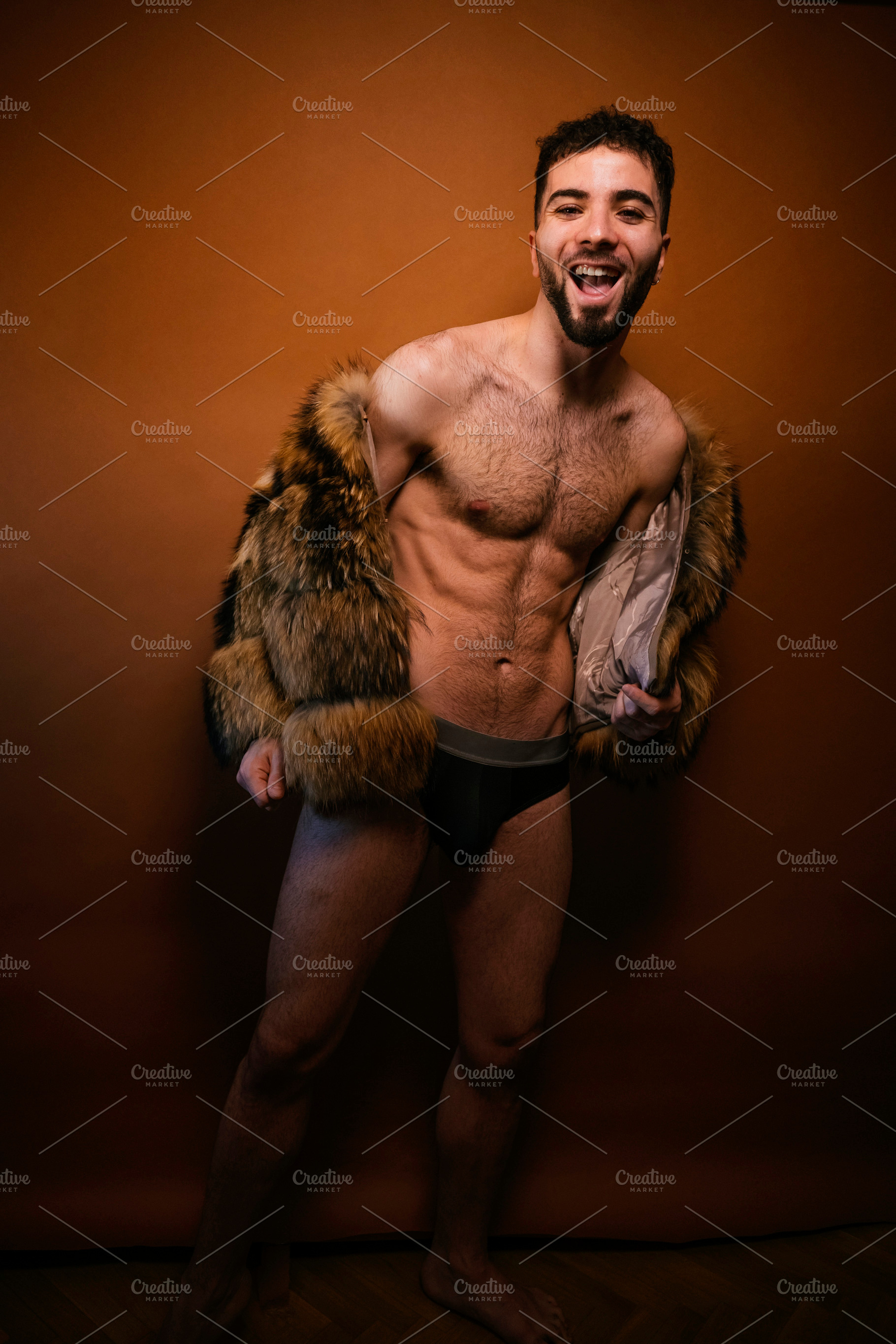 Confident man wearing fur coat and underwear in studio, a Photo by karrastock