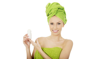 Young woman holding deodorant.