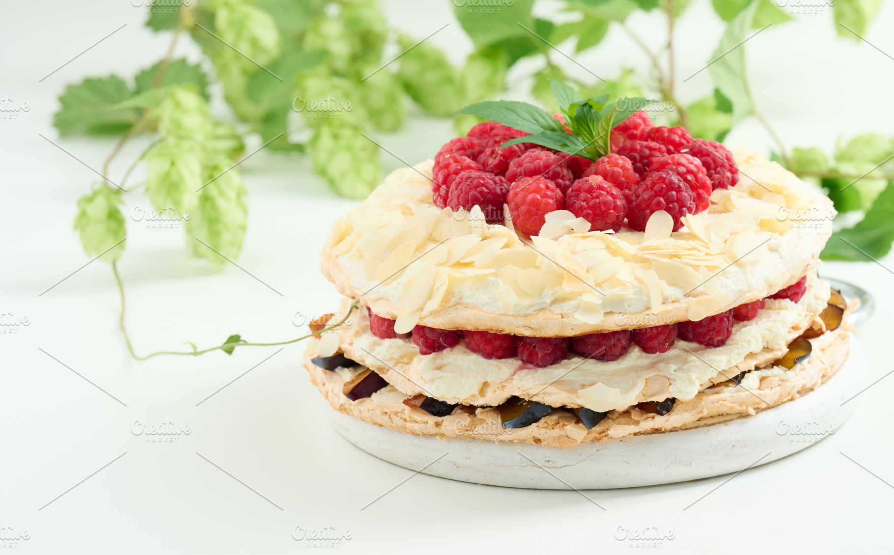 Round meringue pie with fresh raspberries on a white background,, a Food & Drink Photo by ndanko