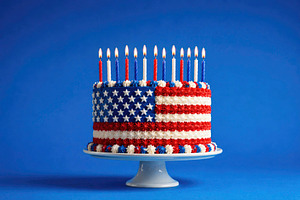 a US flag cake with lit candles, generative AI, a Photo by Nito