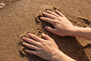 Hands Pressed into Golden Sand, a Nature Photo by Virgo Studio