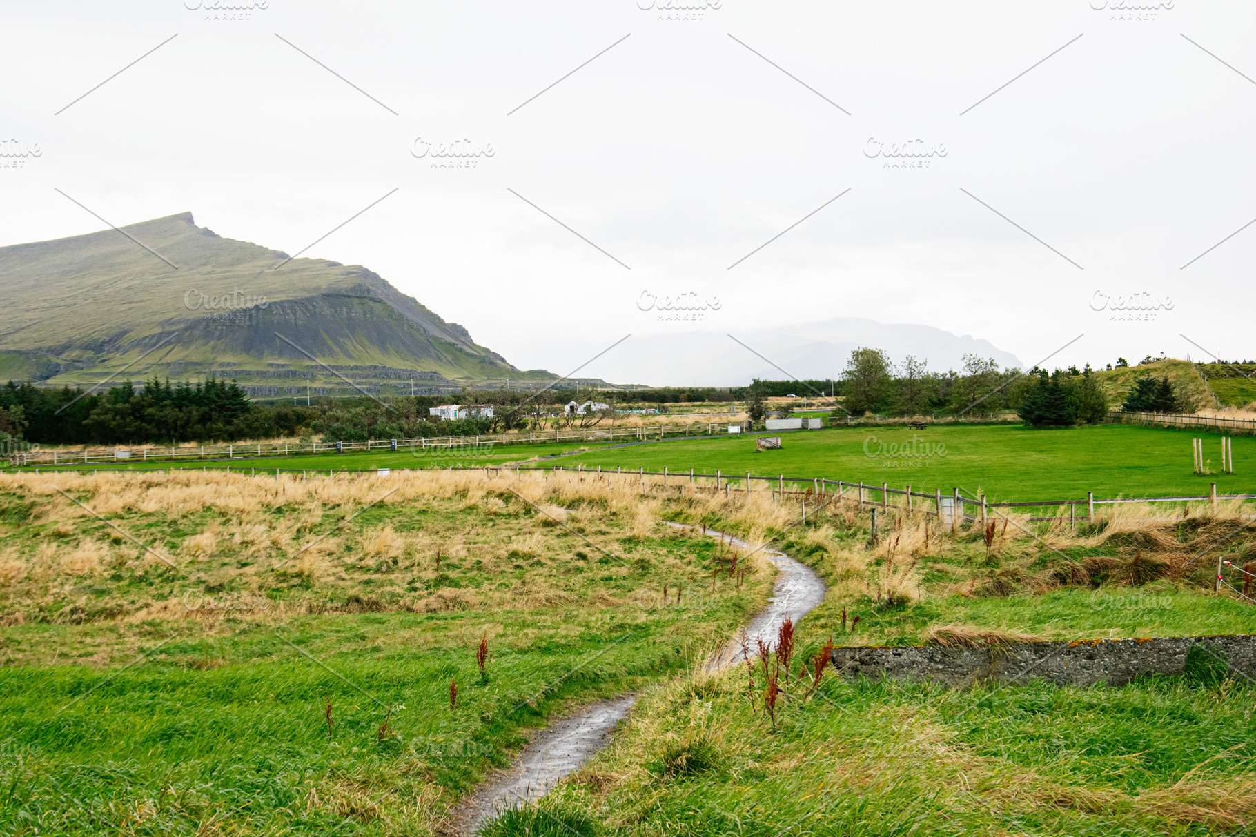 Scenic Icelandic countryside with grassy meadows and distant mountain under clo, a Nature Photo by AS photostudio