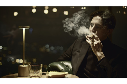 Young man elegantly smokes cigar, a Person Photo by Media Whale Stock