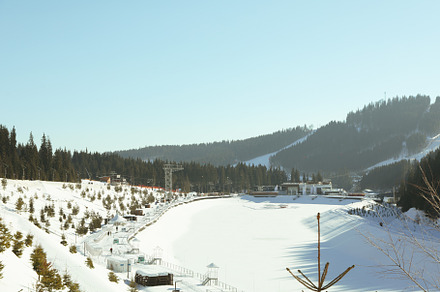 Carpathian mountains with ski resort and lake in sunny day, a Holiday Photo by AtlasStudio