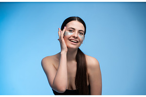 Young woman applying under eye, a Health & Medical Photo by volodymyrshtun13795