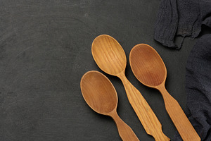 Empty wooden spoons on a dark board with a cloth napkin, top vie, a Food & Drink Photo by ndanko