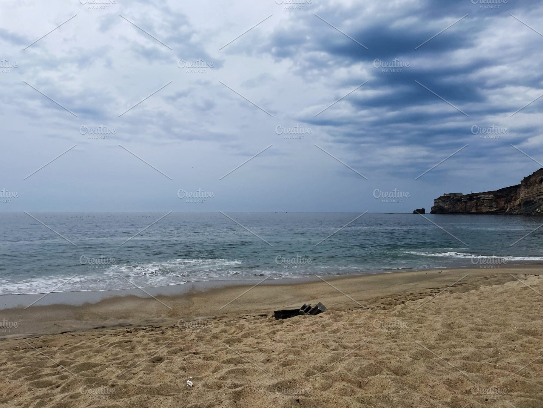 Serene coastal view of a sandy beach with cliffs under a cloudy sky, a Photo by AS photostudio