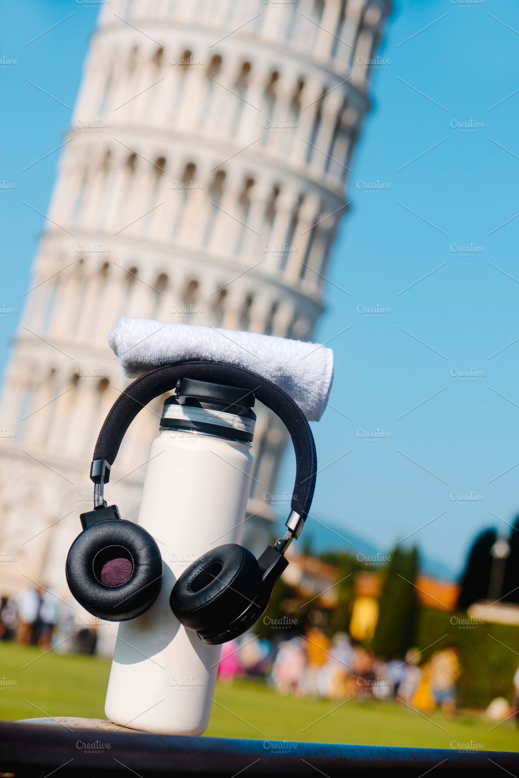 bottle and headphones by the Tower of Pisa, a Photo by Nito