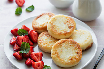 Cottage cheese pancakes, ricotta fritters on ceramic plate with, a Food & Drink Photo by Olena Rudo