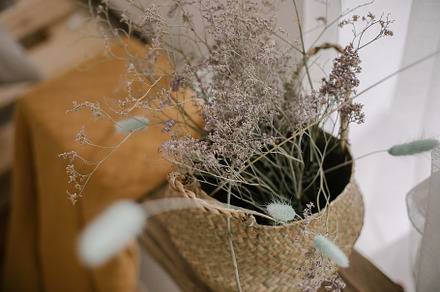 Dry flowers in straw basket on wooden bench in living room, an Arts & Entertainment Photo by Anikona