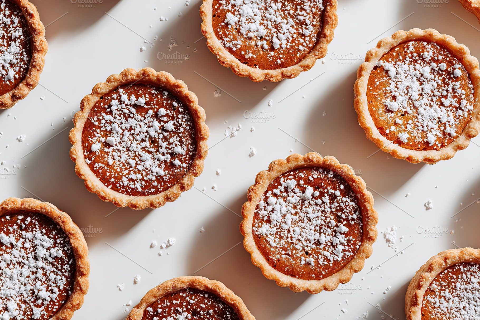 Delicious mini tarts topped with powdered sugar on a light background, a Photo by AlyaAnd