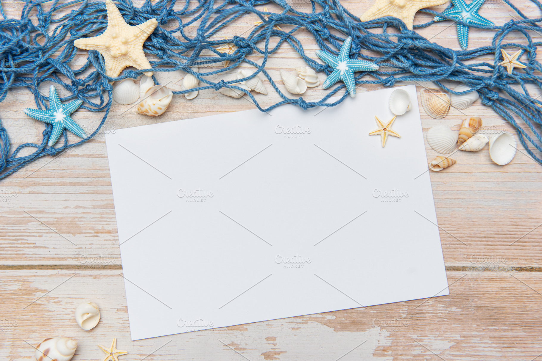 Fishing net, seashells and starfishes framing blank paper on woo, a Holiday Photo by Olena Rudo