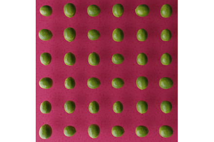 Fresh green limes on a pink red