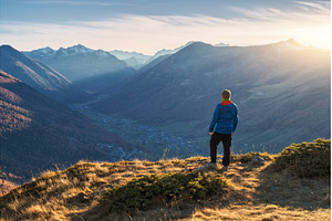 Young man standing on grassy, a Nature Photo by den-belitsky