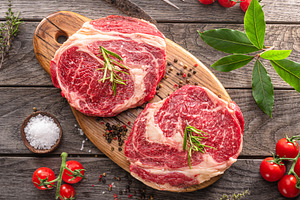 Raw beef steaks with herbs and spices ready for cooking are on w, a Food & Drink Photo by Volff