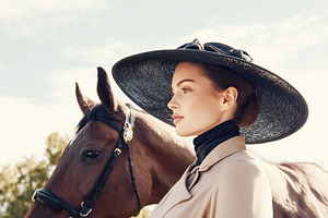 Elegant woman in profile wearing a wide brimmed black hat and be, a Photo by Studio ANNA