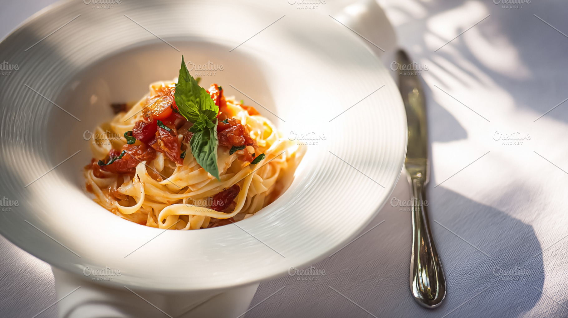 Fresh fettuccine pasta with tomato sauce and basil on a white pl, a Photo by Studio ANNA