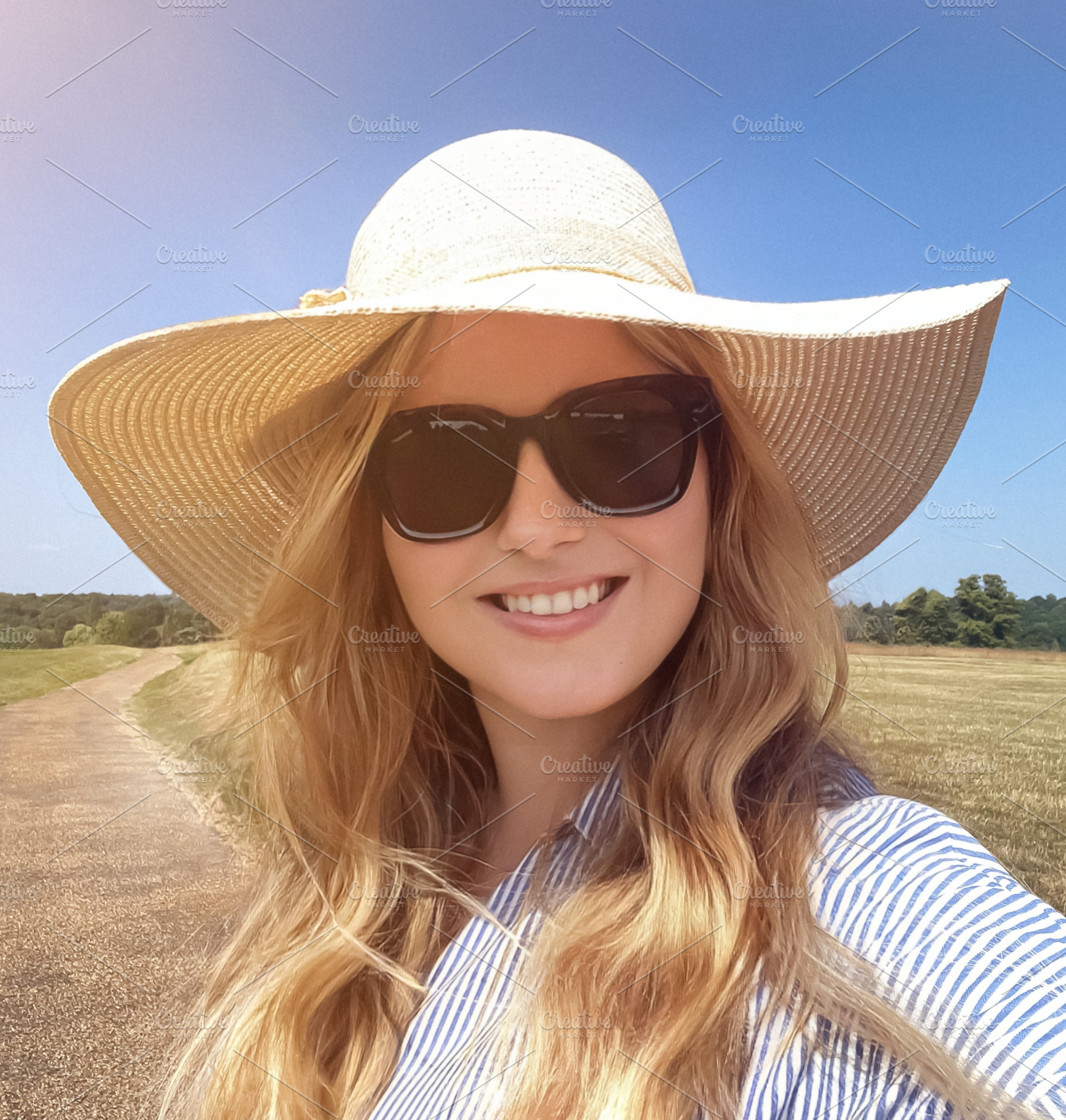Country path stroll on a bright summer day, woman in straw hat a, a Person Photo by Studio ANNA