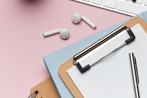 Workspace organizing accessories on pink table with plant and ke, a Business Photo by Olena Rudo