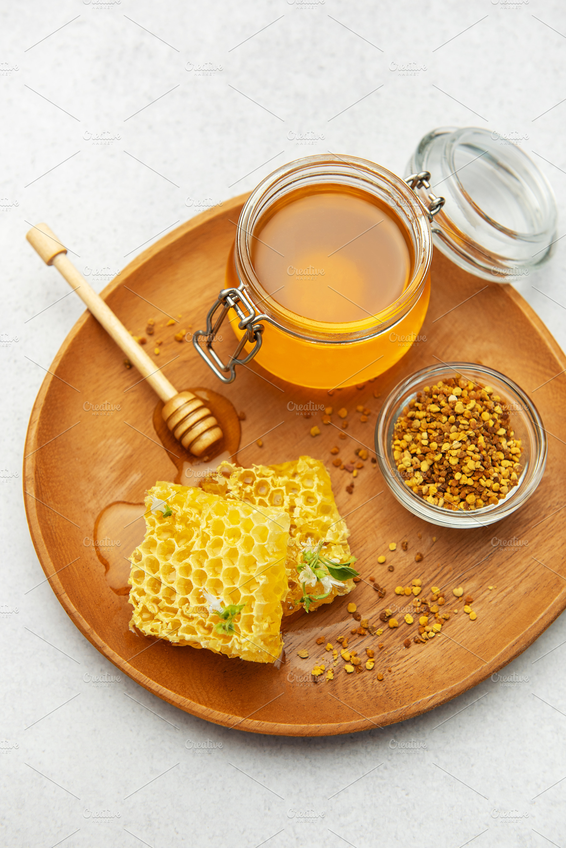 Jars and honeycombs resting on wooden tray, promoting natural sw, a Food & Drink Photo by Olena Rudo