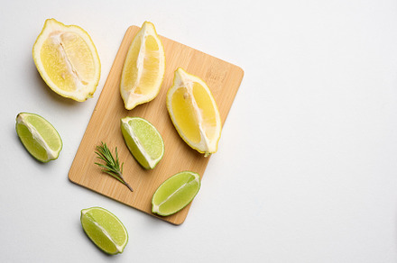 Various lemon and lime slices on a wooden board, top view, a Food & Drink Photo by ndanko