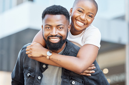 Piggyback, black couple and portrait in city for love, care and happiness on date together in Nigeria. Happy man carrying woman in urban street, town and outdoor for fun, freedom and relax with smile, a Photo by Peopleimages.com