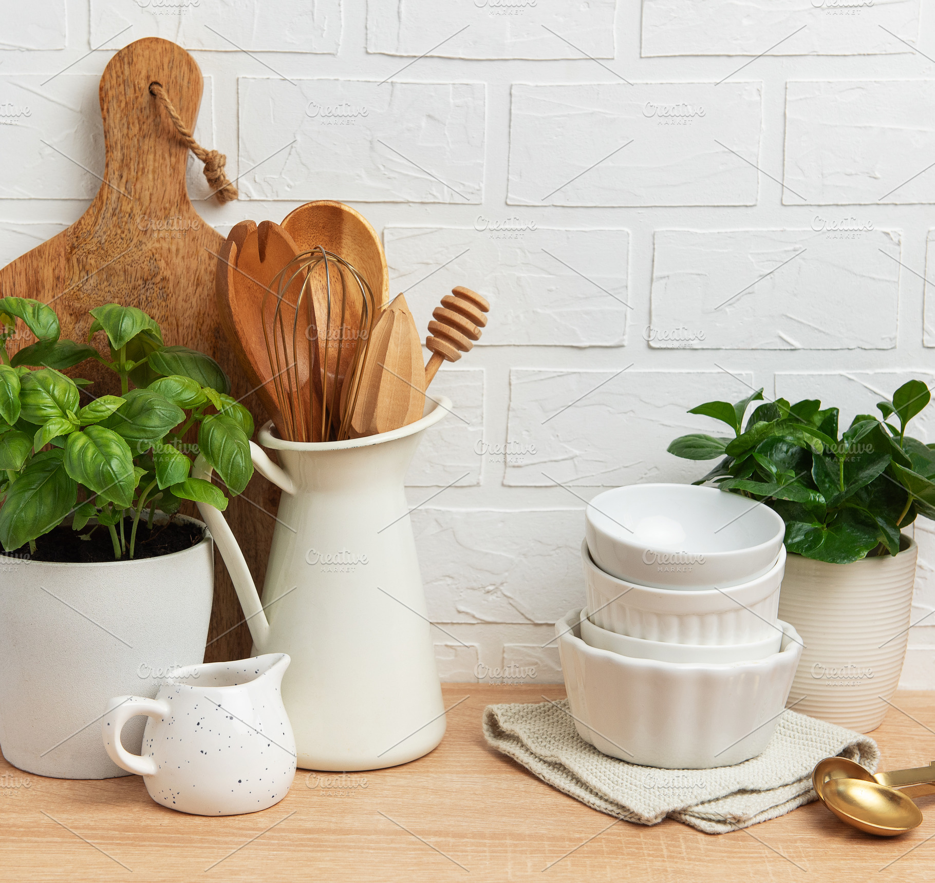 Kitchen utensils and plants creating cozy atmosphere on wooden c, a Food & Drink Photo by Olena Rudo