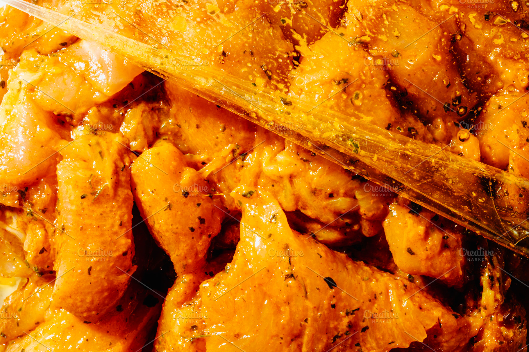 raw chicken marinating with spices in a plastic bag, a Photo by Nito