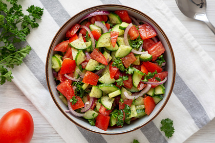 Homemade Mediterranean Cucumber Tomato Salad in a Bowl, top view, a Food & Drink Photo by LiudmylaChuhunova