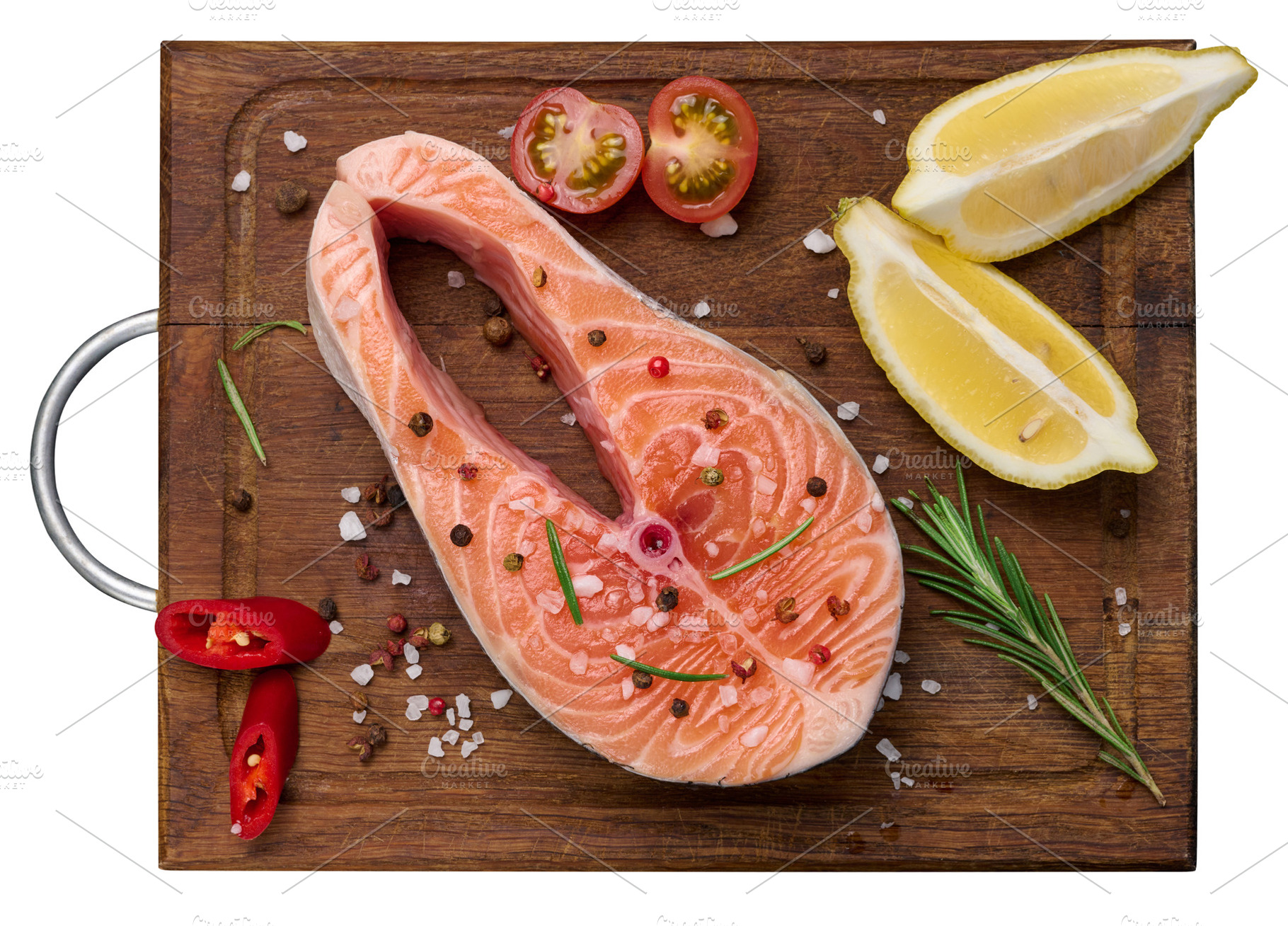Raw salmon steak on a wooden cutting board, lemon slices, spices, a Food & Drink Photo by ndanko