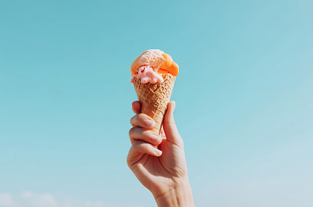 Hand holding a melting ice cream cone under a clear blue sky on a sunny day, a Food & Drink Photo by AlyaAnd