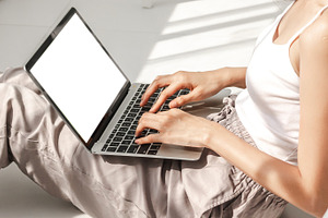 Asian woman relaxing using laptop computer working with white mo