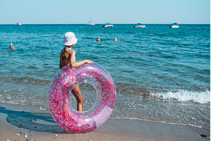 Girl on beach with swim ring during, a Sports & Recreation Photo by HalfPoint