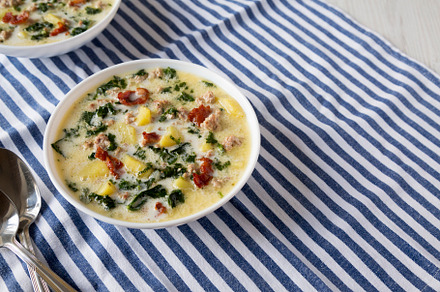 Homemade Zuppa Toscana with Kale and Bread in a white bowl, side, a Food & Drink Photo by LiudmylaChuhunova