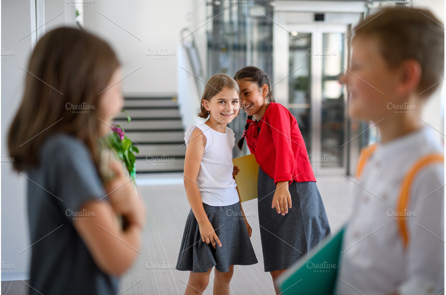 Schoolgirls teasing or gossiping, a School & Education Photo by HalfPoint