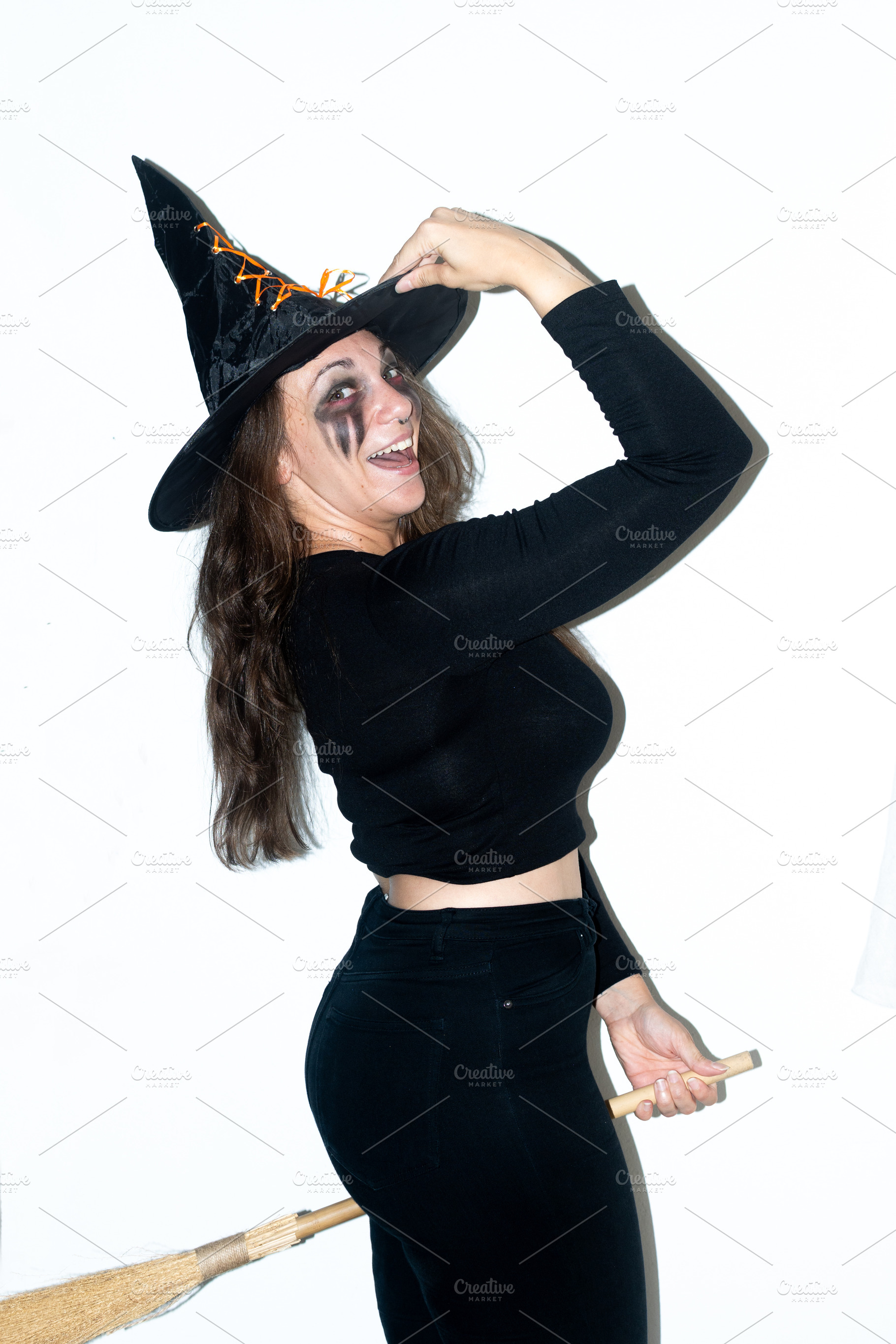 Happy woman dressed as a witch posing with broom for Halloween, a Person Photo by etorres69