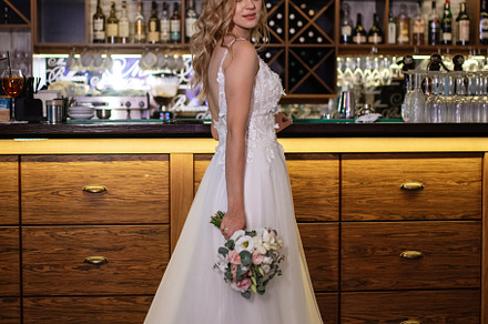 blonde bride in a bar near with a wedding bouquet, a Person Photo by Weddings, People, Travel