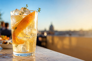 Citrus daycap drink with ice, orange peel and thyme on rooftop b, a Photo by Dvoevnore photos