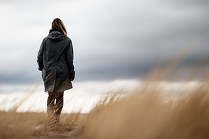 Woman in a dark coat walking through, a Person Photo by MistyDay