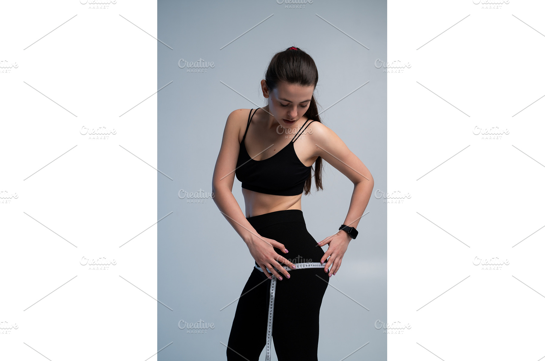 Young woman measuring hips with a, a Sports & Recreation Photo by volodymyrshtun13795