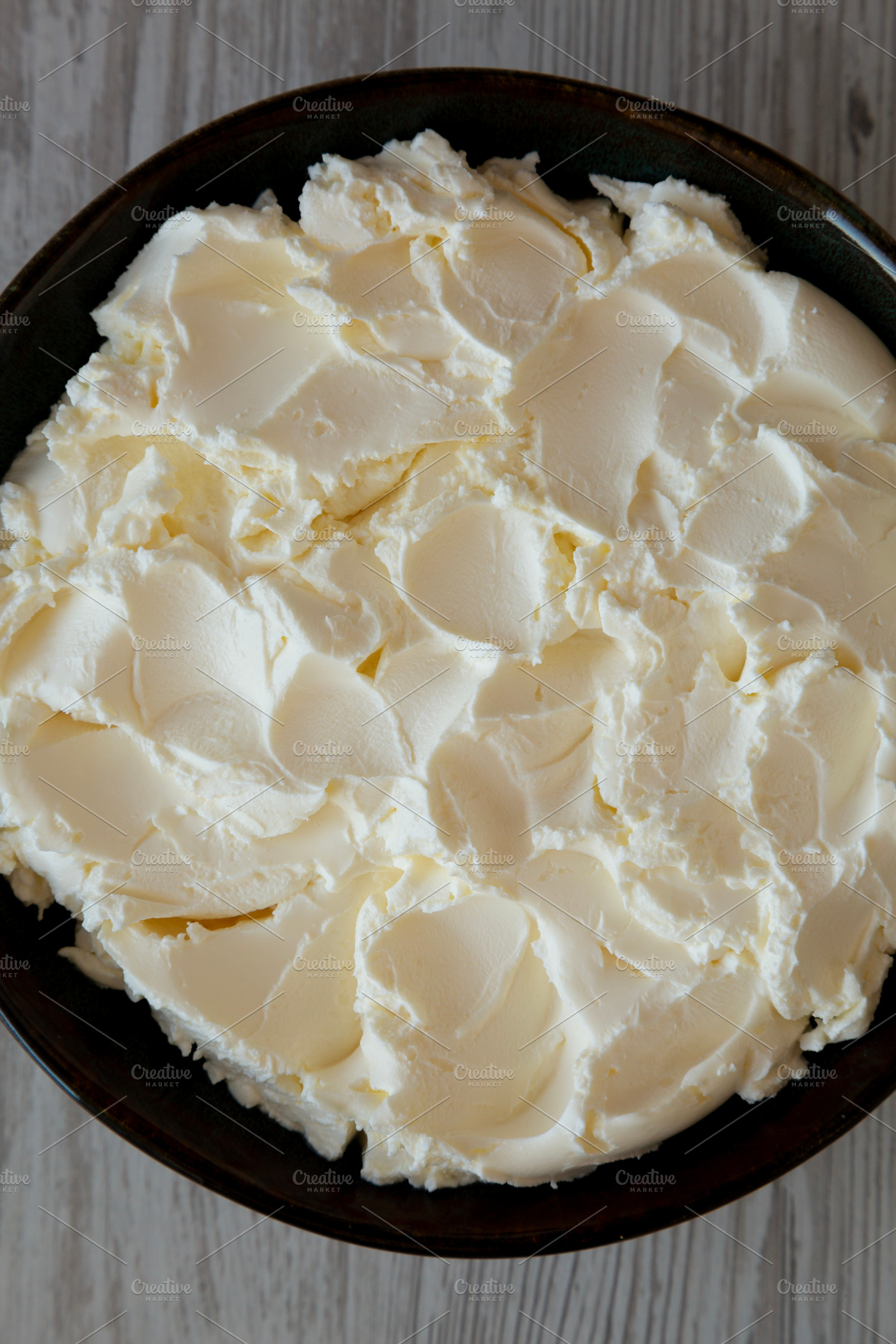 Organic White Mascarpone Cheese in a Bowl, top view., a Food & Drink Photo by LiudmylaChuhunova