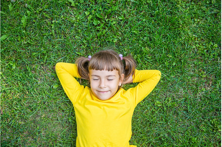 The child lies on the grass, a Person Photo by yanadjana