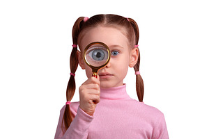 Young girl in pink sweater looking through magnifying glass, iso, a Person Photo by Ales Munt