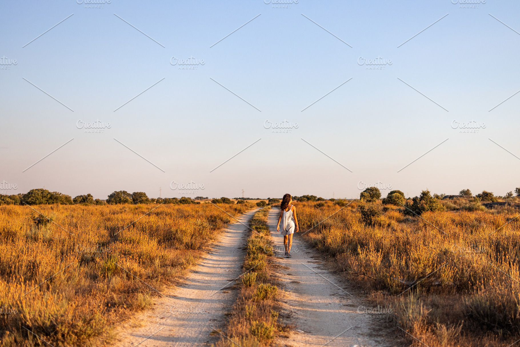 Lonely girl walking on a country road. Back view., a Person Photo by Cosca