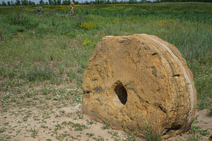 An ancient millstone with a hole in the center against the backg, a Nature Photo by ndanko