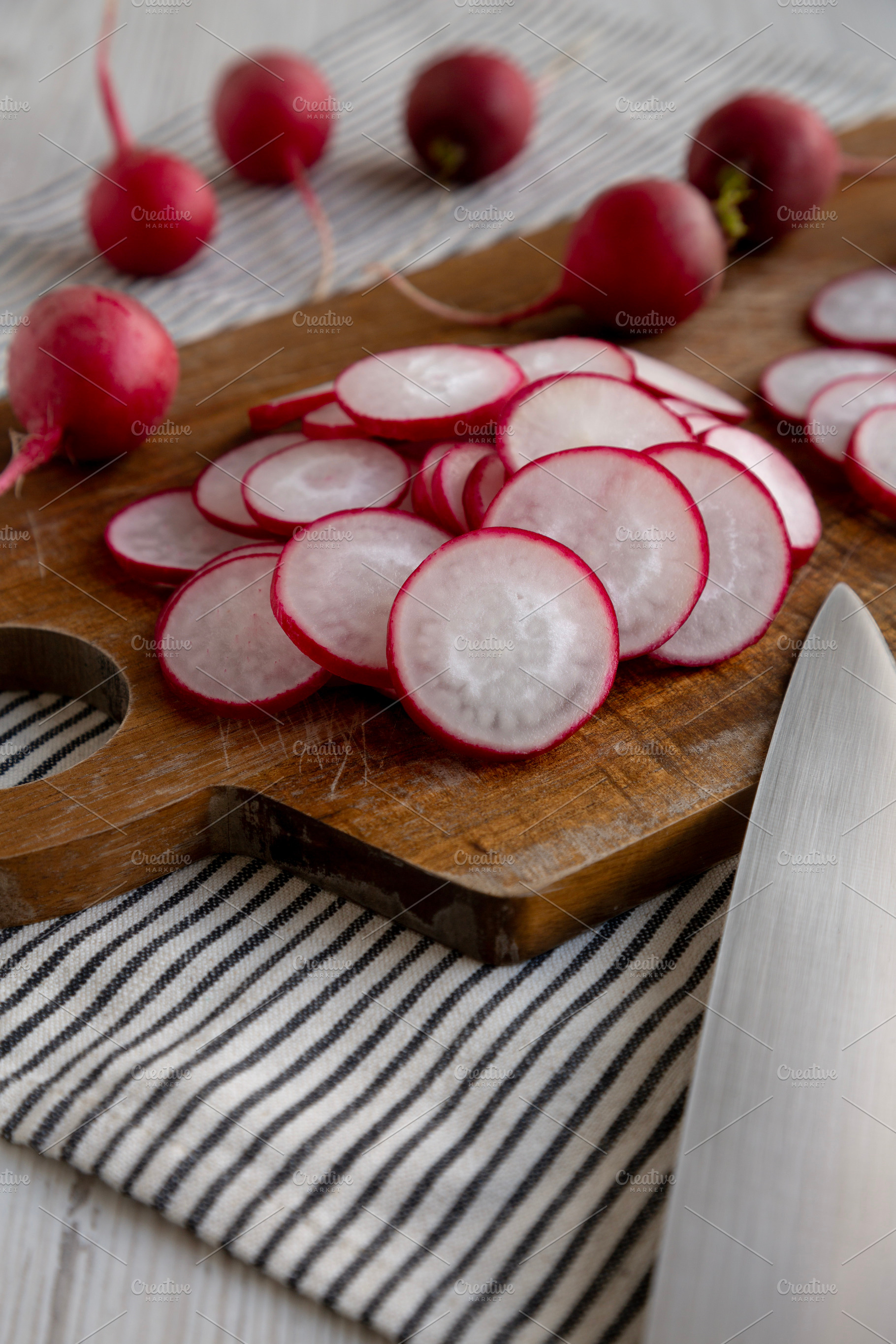 Raw Red Radish Slices on a Cutting Board, side view., a Food & Drink Photo by LiudmylaChuhunova