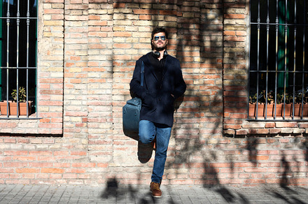Man leaning on a brick wall wearing sunglasses and headphones., a Person Photo by RF Images