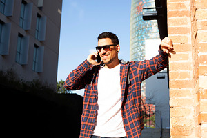 Caucasian man smiling on phone call in modern city street, a Person Photo by RF Images
