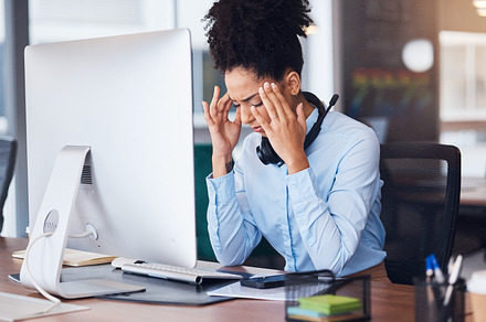 Headache, stress and business black woman at desk with computer problem, head pain and fatigue in office. Burnout, mental health and female worker tired, frustrated and overworked with migraine, a Photo by Peopleimages.com
